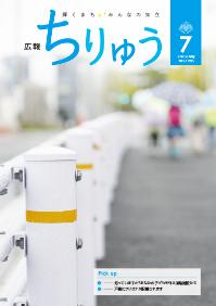広報ちりゅう7月号の表紙。手前にはガードパイプがあり、奥に子供たちが歩いている。